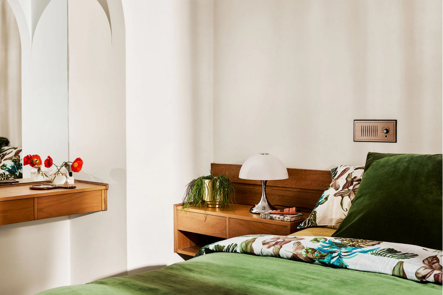 A-1970s-inspired-bedroom-with-green-velvet-Kip-and-Co-bedding-timber-furniture-pieces-and-a-mushroom-lamp