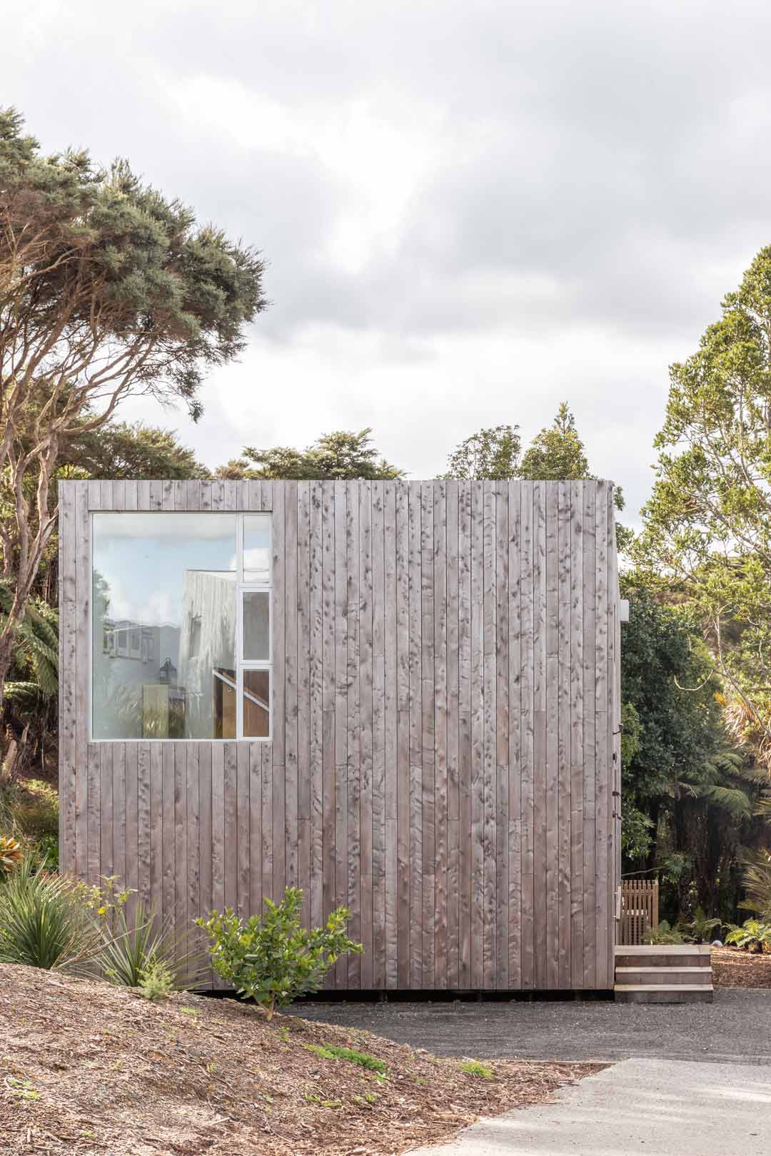 A-box-shaped-tiny-home-with-a-small-footprnt-in-New-Zealand-blends-into-the-coastal-landscape