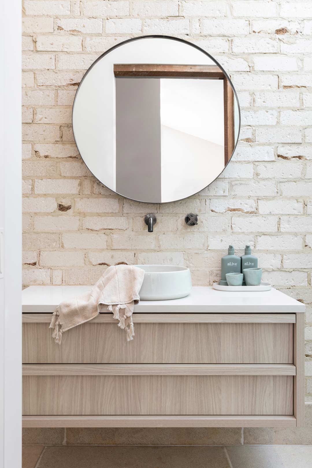 A-caostal-bathroom-with-sand-coloured-bricks-a-ceramic-round-basin-and-brushed-gunmetal-tapware