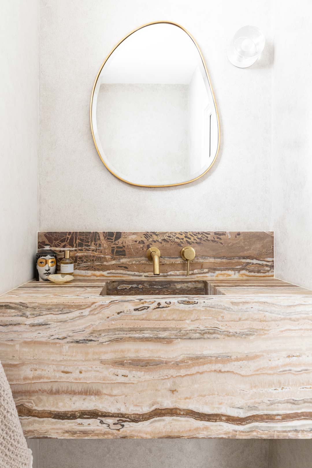 A-marble-basin-paired-with-brushed-brass-tapware-give-a-modern-twist-on-an-art-deco-bathroom