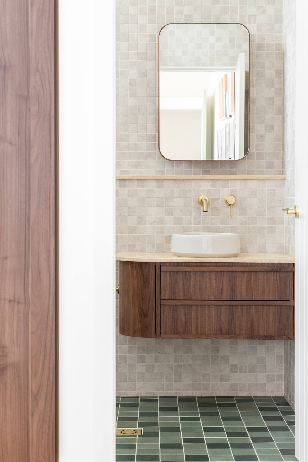 A-mid-century-modern-bathroom-with-walnut-timber-vanity-retro-green-square-floor-tiles-and-brushed-brass-tapware
