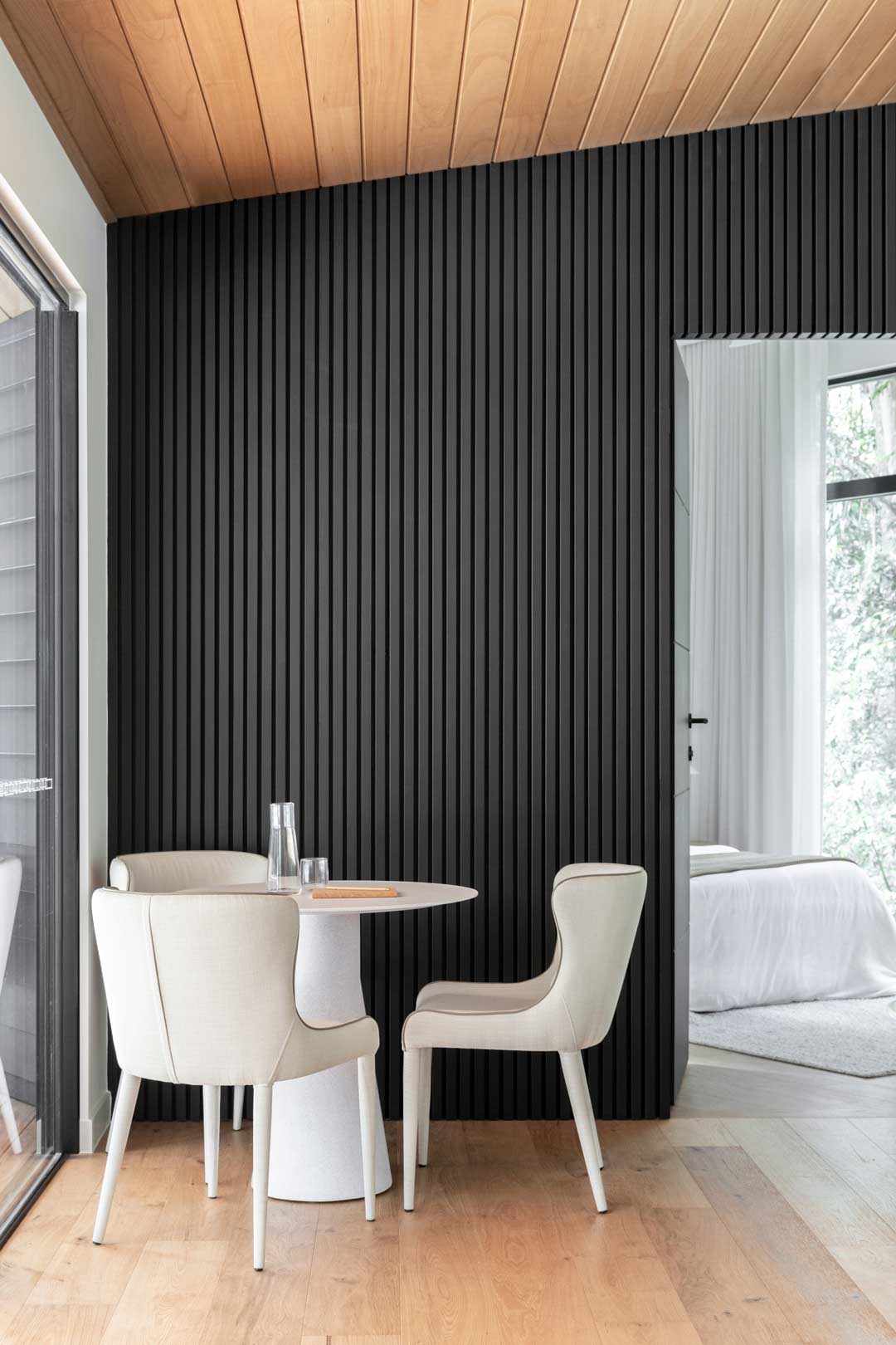 A-monochromatic-teenage-retreat-with-warm-timber-on-the-ceiling-and-floor-and-contrasting-black-vertical-panneling