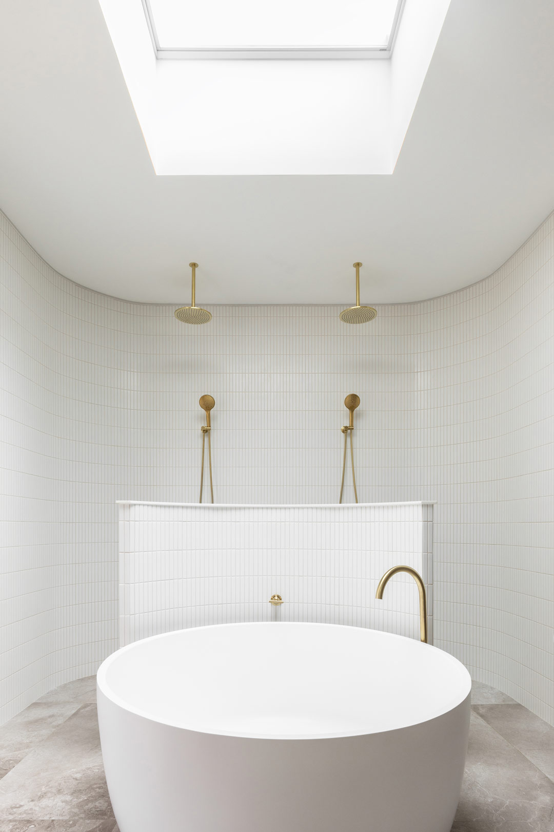 A-neutral-bathroom-interior-design-in-a-luxurous-ensuite-featuring-brushed-brass-tapware-a-double-shower-and-a-circular-bath
