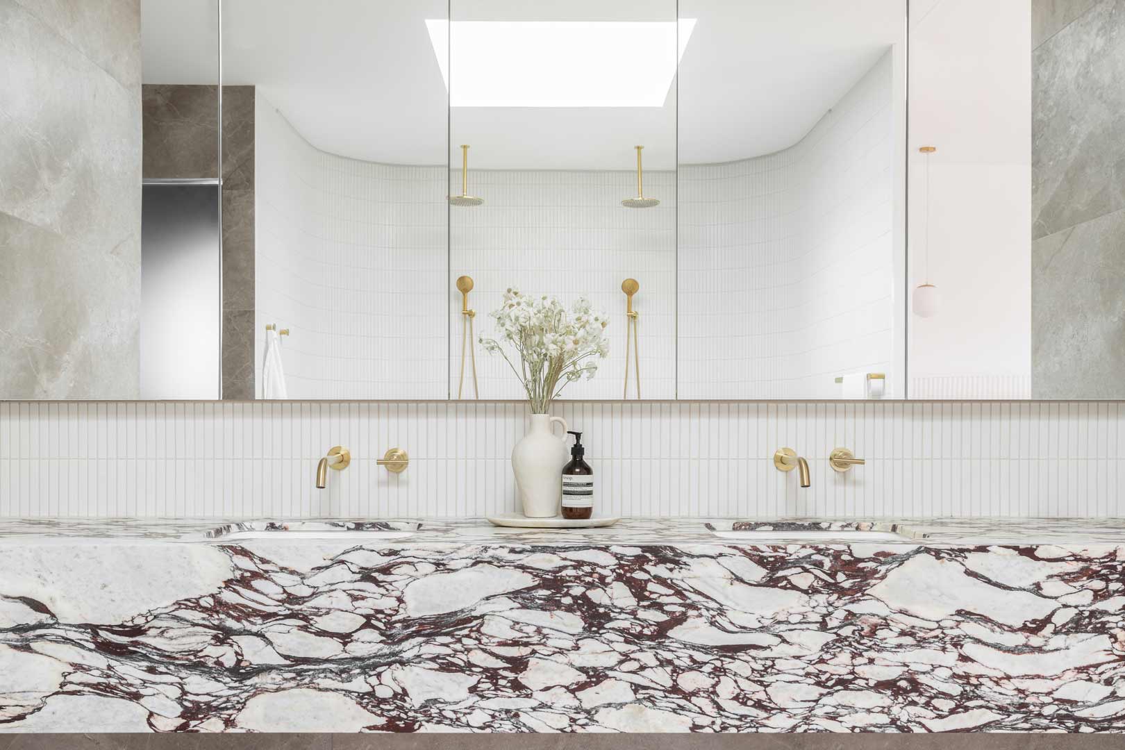 A-neutral-simple-luxury-bathroom-paired-with-brushed-brass-tapware-and-a-purple-violet-natural-stone-vanity-feature