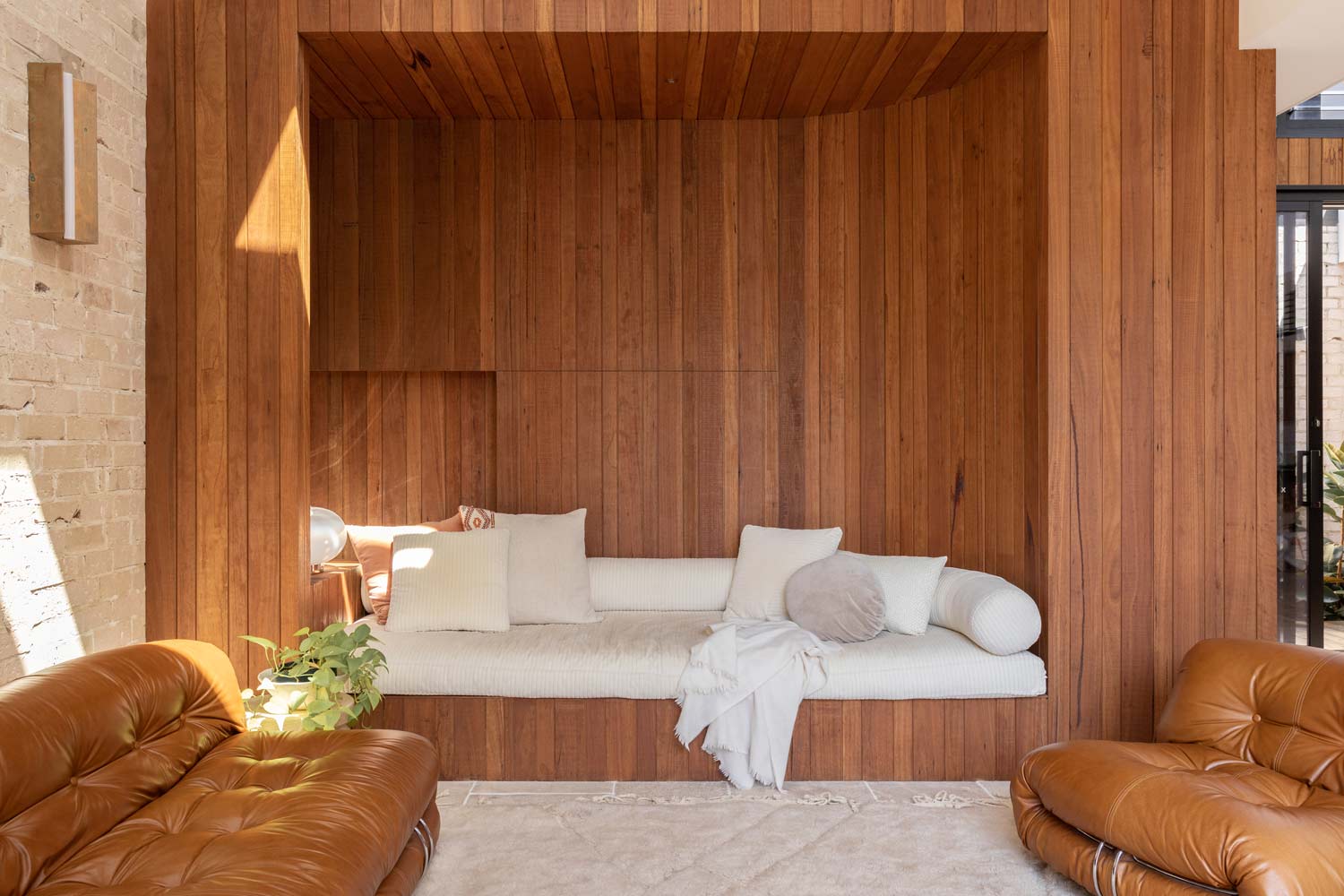A-warm-timber-paired-with-tan-leather-lounges-and-light-brickwork-in-the-adults-living-room-of-Shelley-Crafts-Pacifico-House