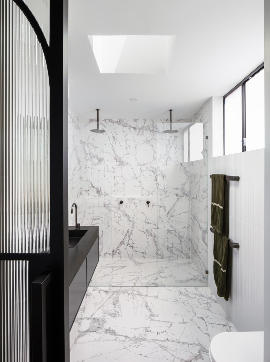 An-aesthetic-double-shower-with-brushed-gunmetal-tapware-and-marble-feature-stone