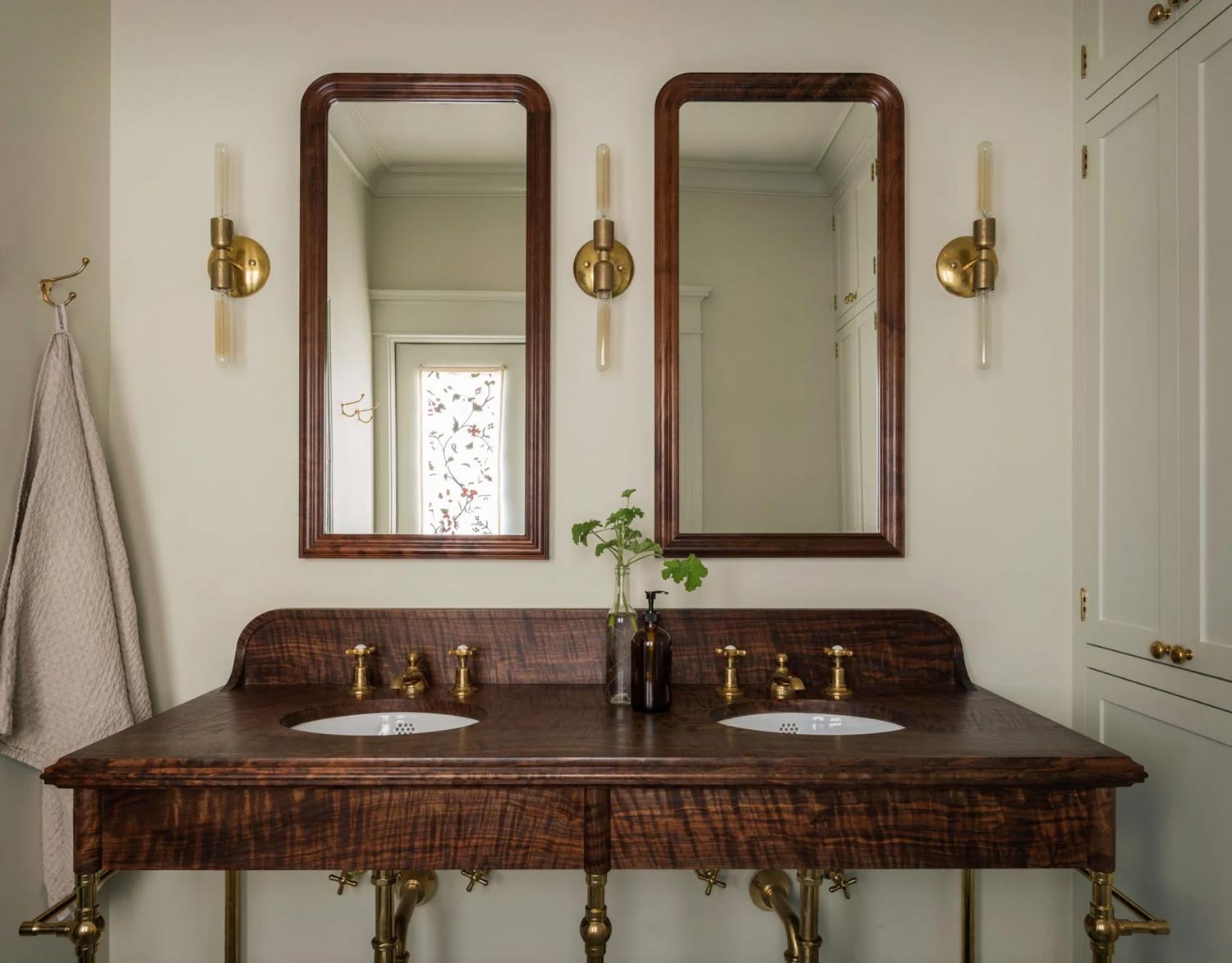 Art-deco-wall-sconces-paired-with-a-polished-timber-vanity-and-brushed-brass-tapware