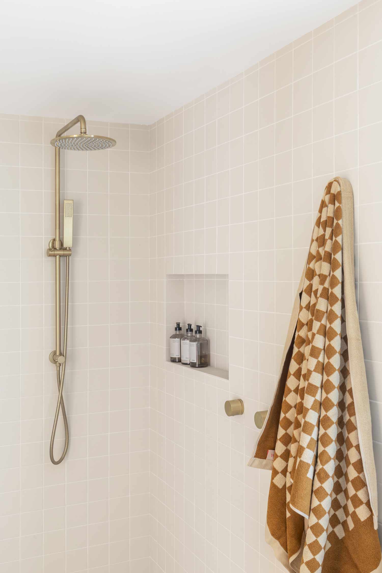 Brushed-brass-feature-tapware-in-a-modern-coastal-bathroom-with-soft-earthy-tones