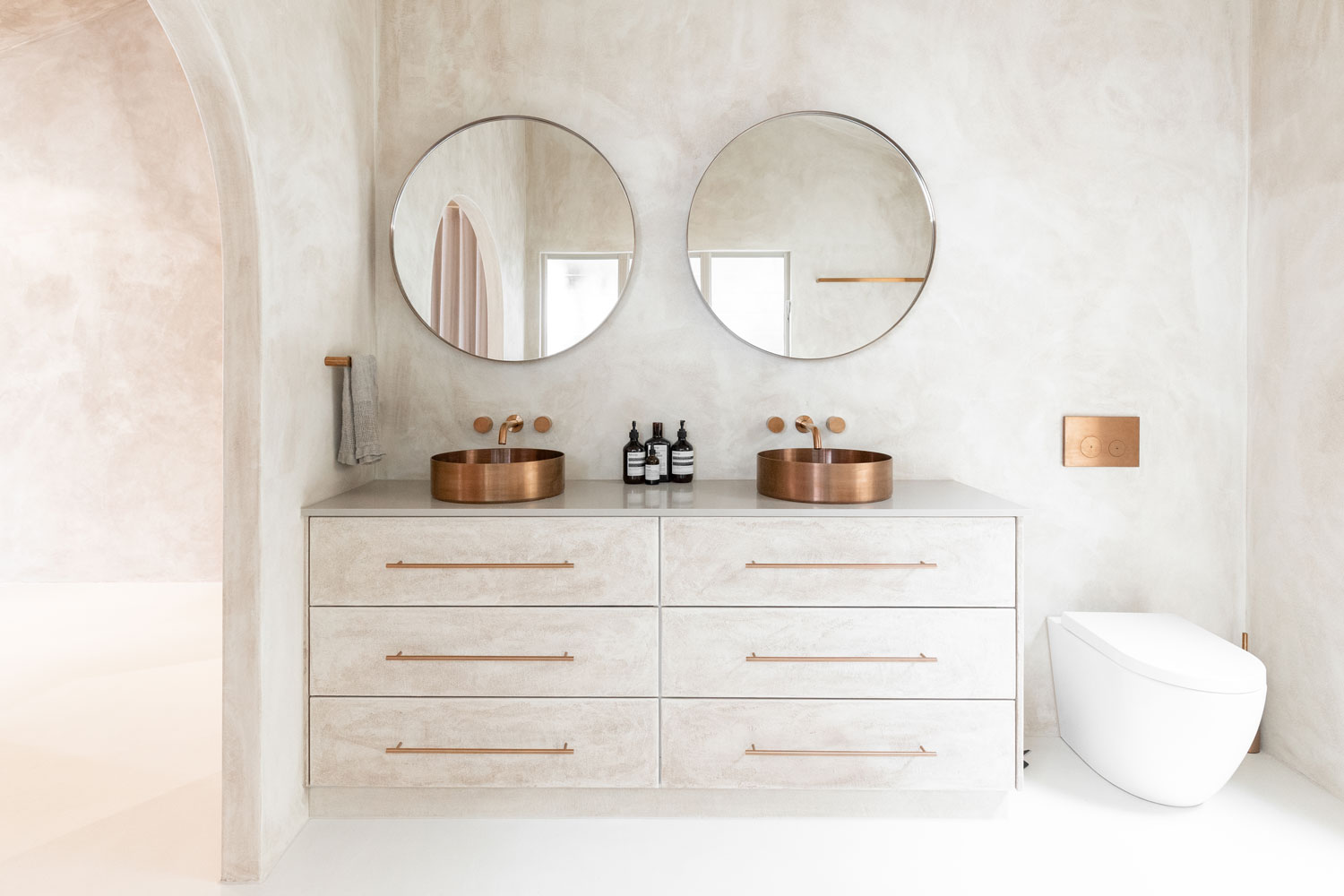 Cohesive bathroom design with round mirrors and matching round basins