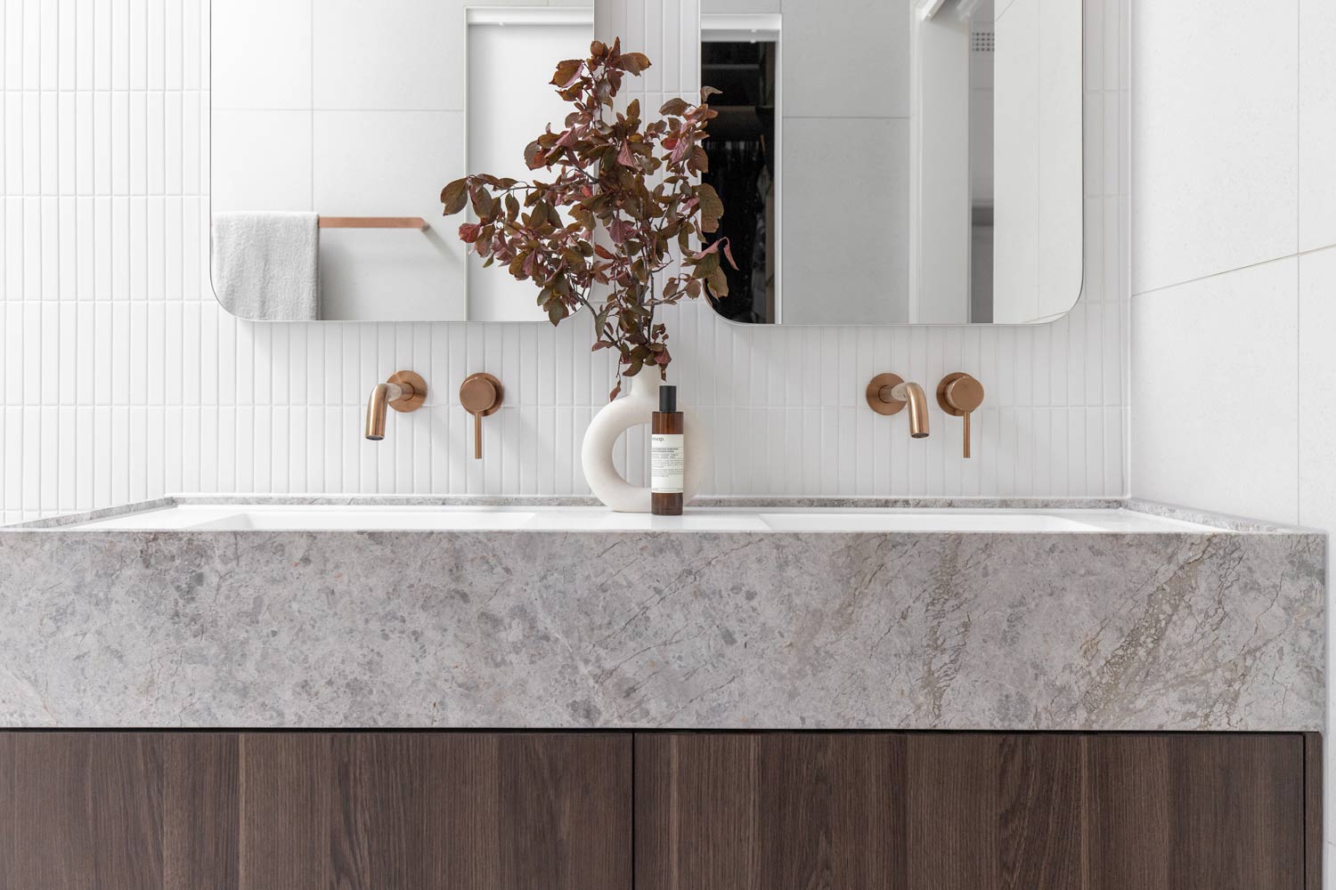 Copper-bathroom-design-with-marble-basin-and-cohesive-floral-arrangement-