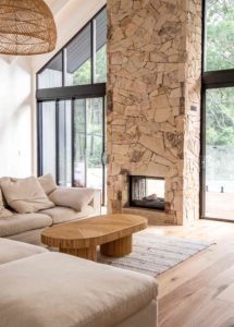 Earth-tone-cosy-living-room-with-stone-fireplace-and-rattan-pendant-light