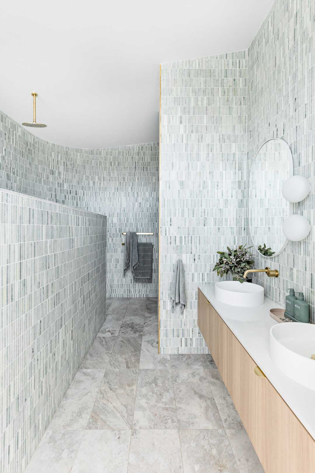 Green-and-blue-finger-tiles-paired-with-brushed-brass-tapware