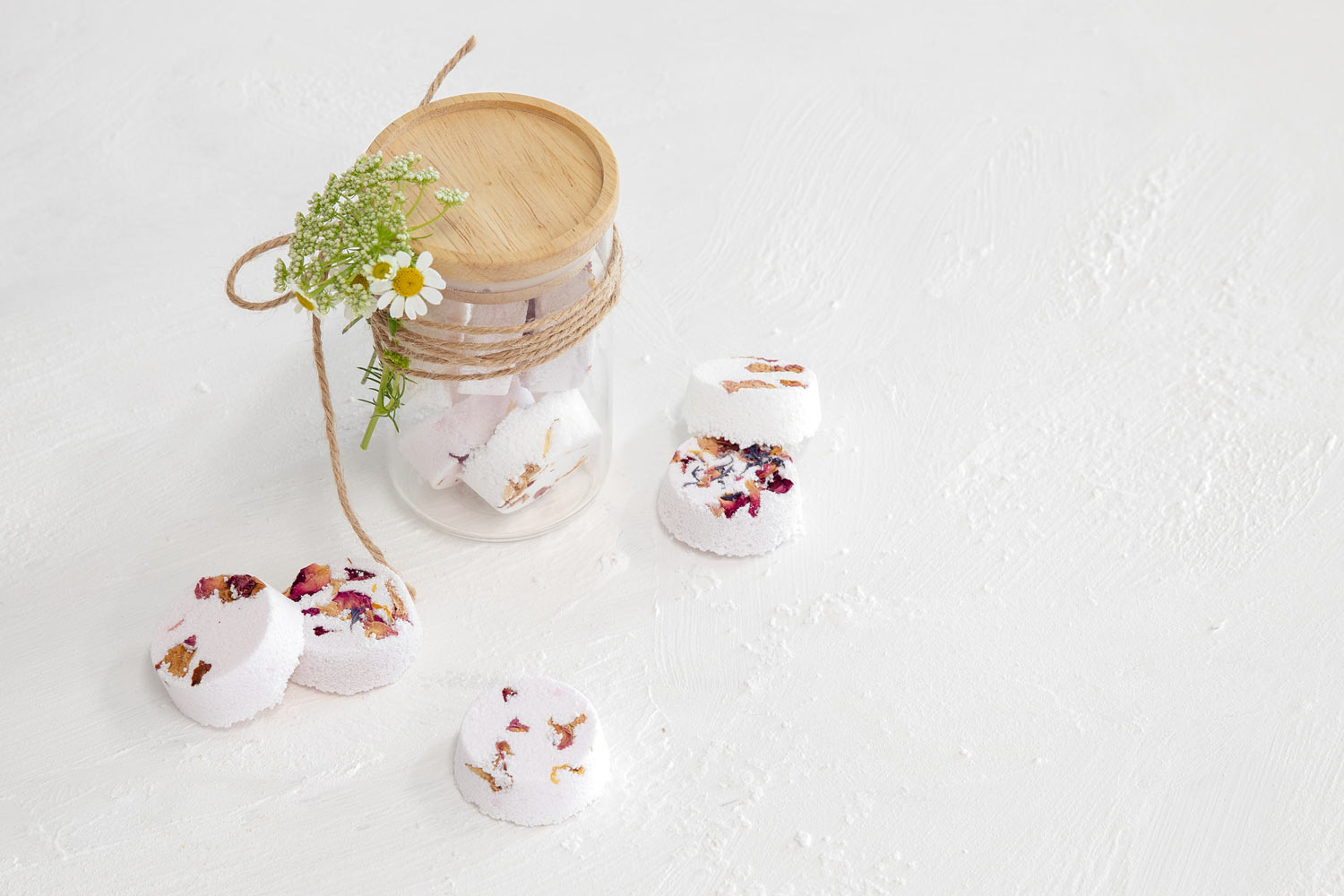 Homemade-shower-or-bath-bombs-in-a-glass-jar-wrapped-with-twine-and-some-Easter-daisies.jpg?format=webp&width=1040