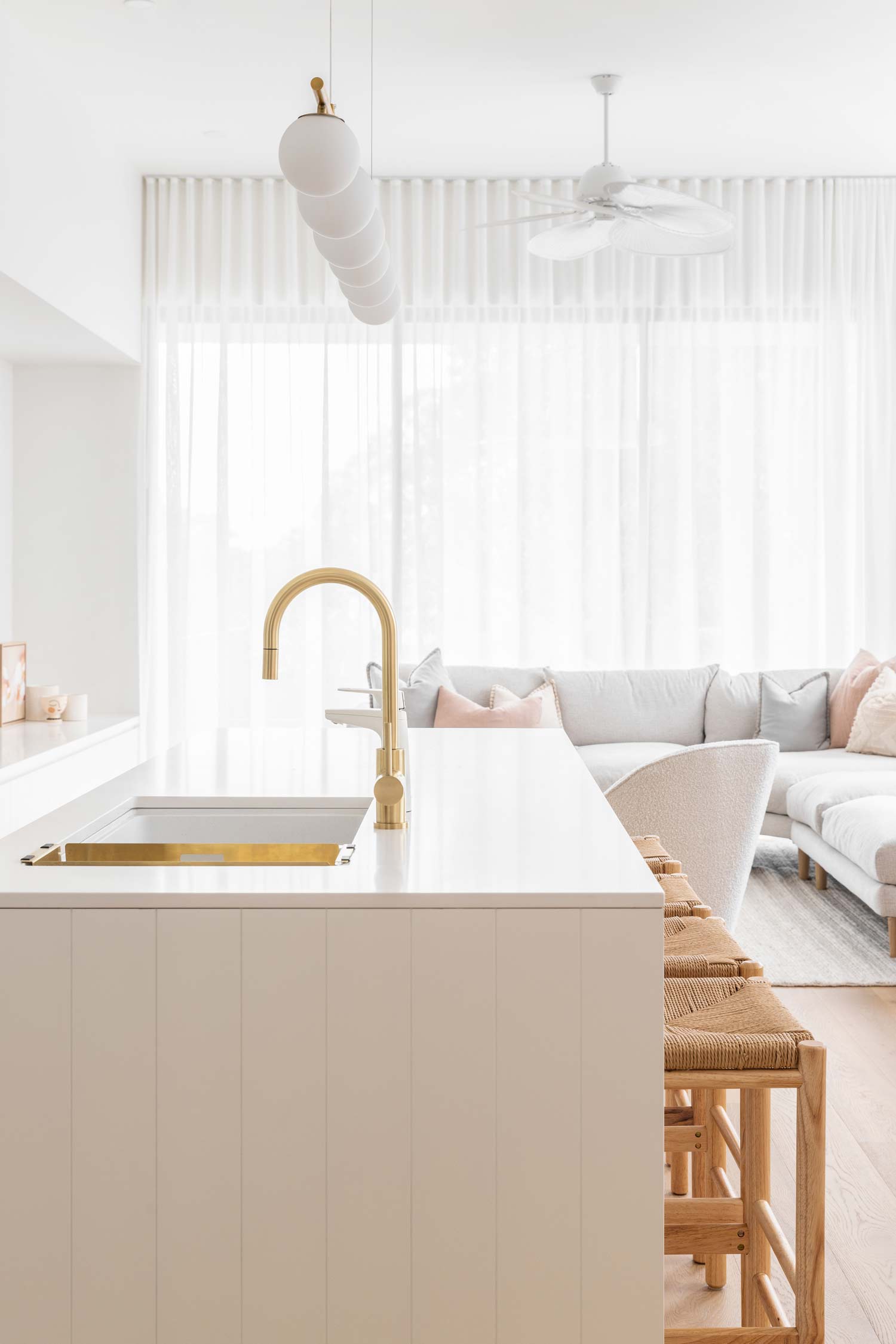 Light-bright-open-plan-high-celing-living-room-with-brushed-brass-kitchen-tapware