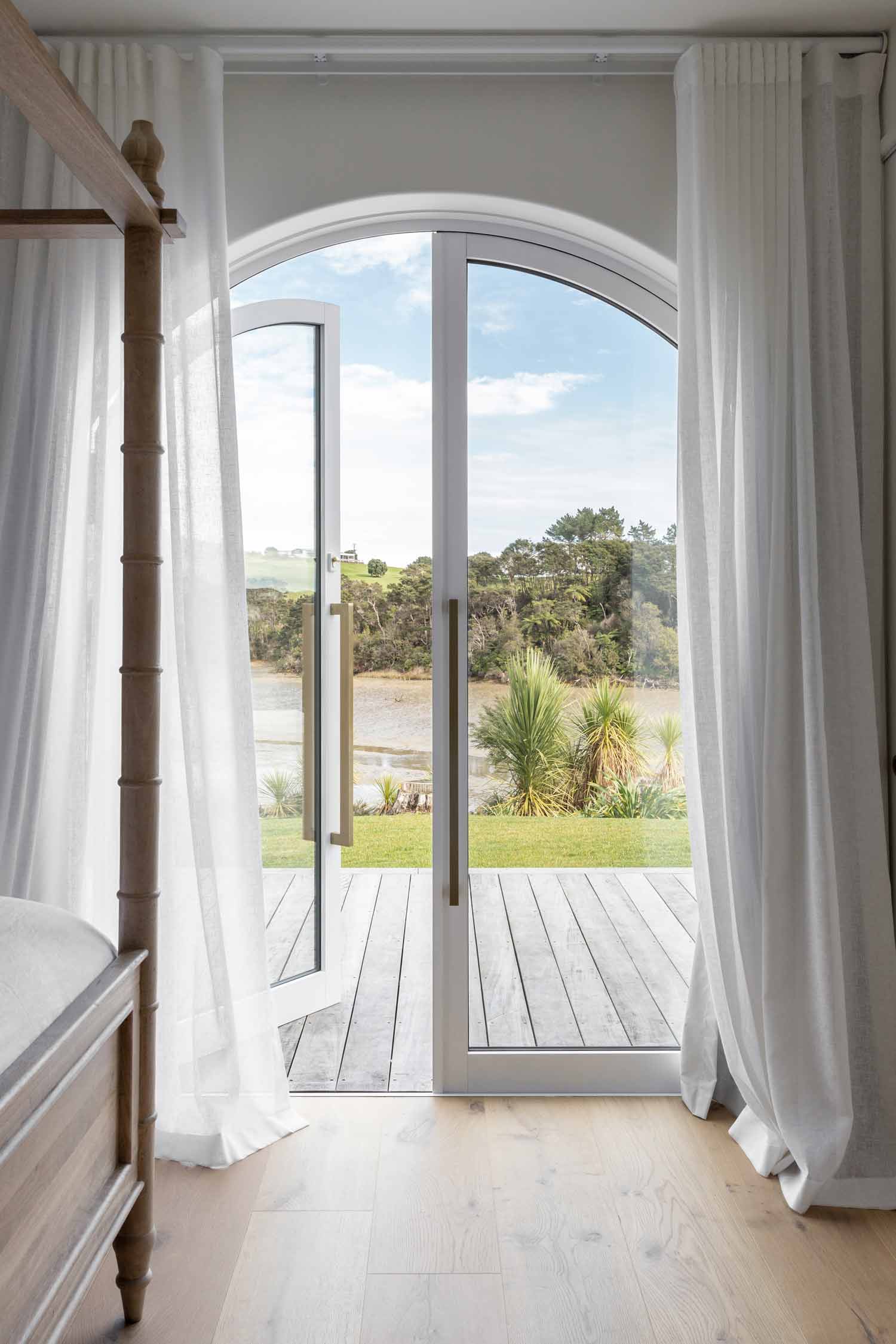 Master-bedroom-view-in-a-modern-mediterranean-home-arched-doors-and-soft-sheer-curtains