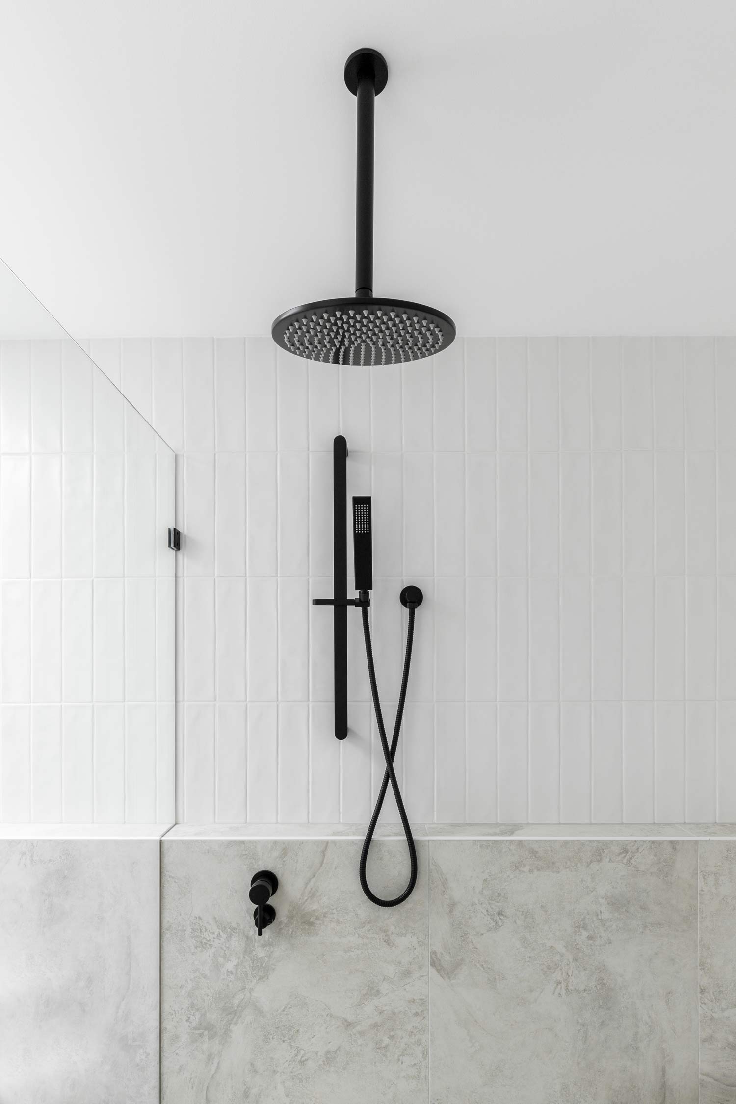 Matte-black-shower-fittings-in-a-high-celing-modern-coastal-duplex-home-with-fresh-white-subway-tiles-and-soft-grey-tiles