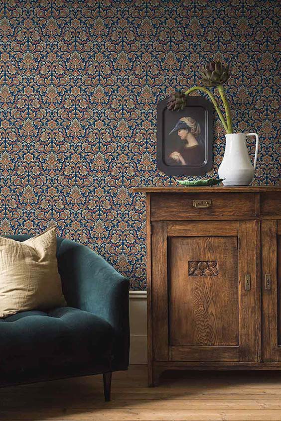 Old-money-aesthetic-living-room-with-demask-wallpaper-heavy-vintage-timber-sideboard-and-a-velvet-blue-armchair-1