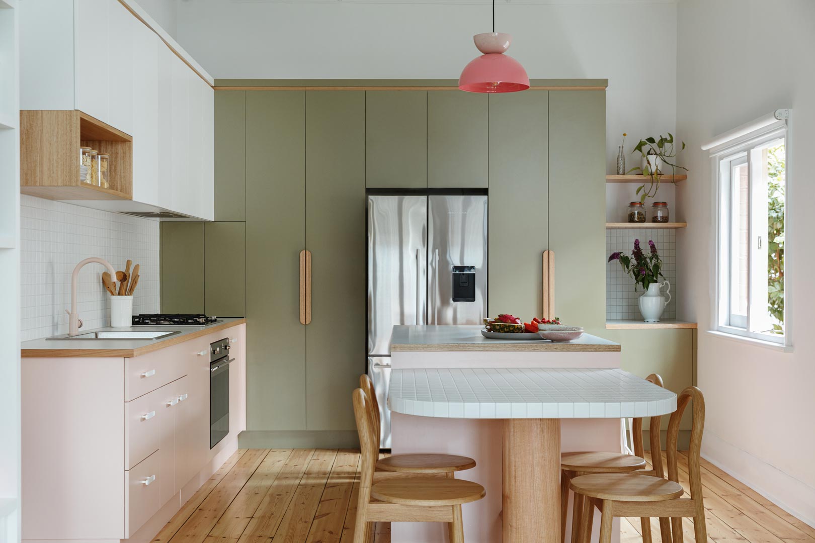 Retro-pastel-pink-and-green-kitchen-with-a-pastel-pink-tap-and-white-tiled-spashback-and-breakfast-bar