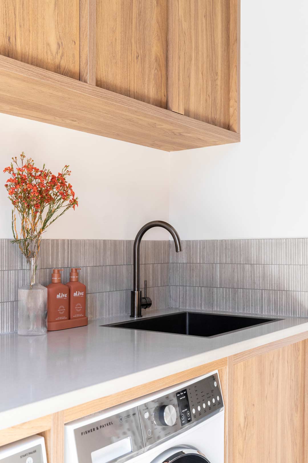 Shelley-Crafts-laundry-features-brushed-gunmetal-sink-tapware-and-travertine-slither-feature-tiles