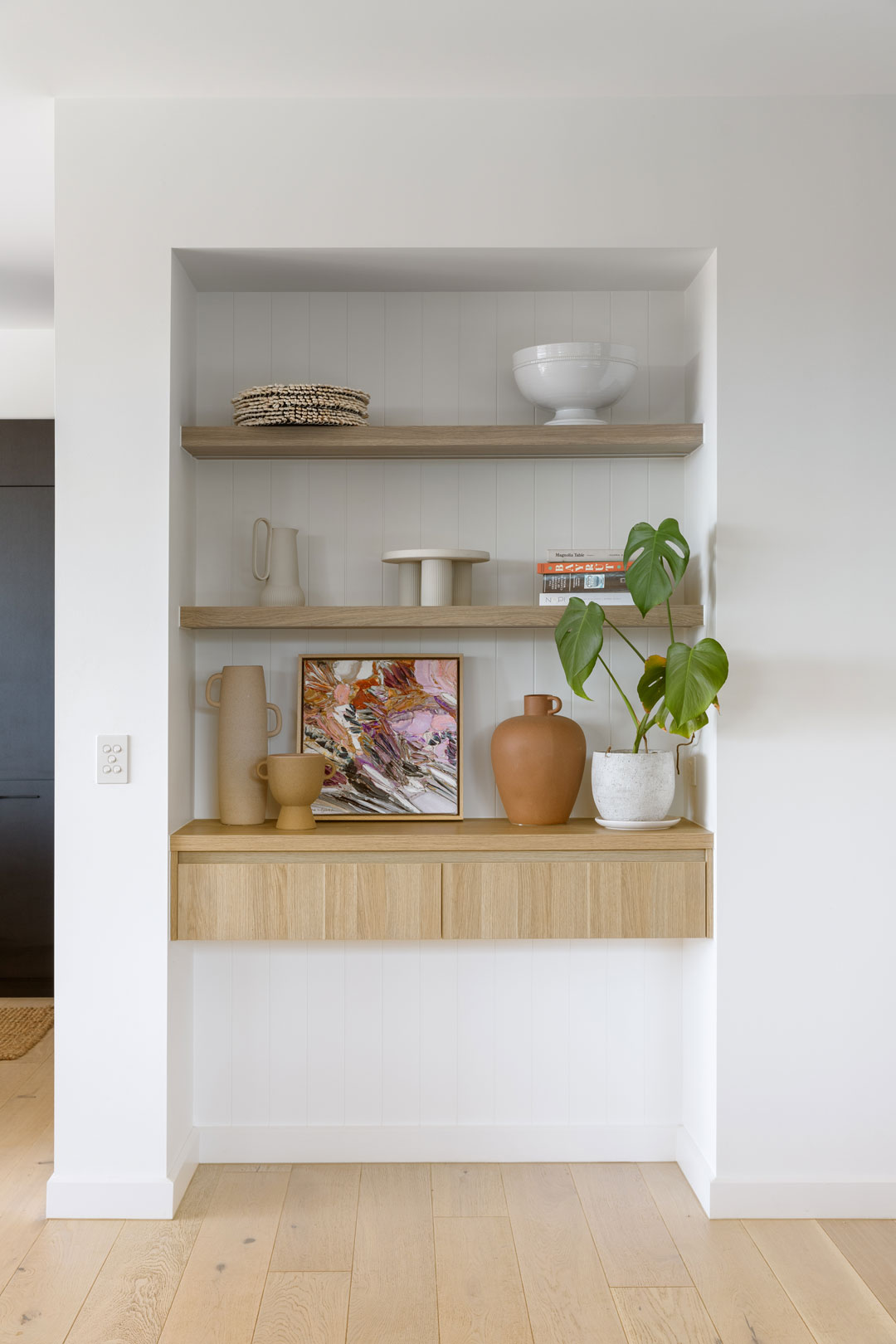 Styled-open-shelves-recessed-into-the-wall-in-a-modern-living-room-to-make-use-of-space