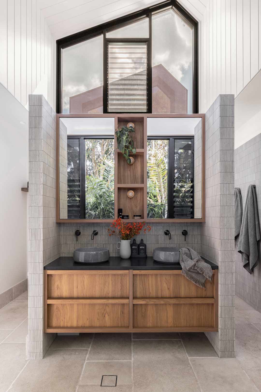 The-master-ensuite-in-Shelley-Crafts-Pacifico-House-Build-features-brushed-gunmetal-tapware-round-ceramic-basins-and-a-timber-vanity-unit