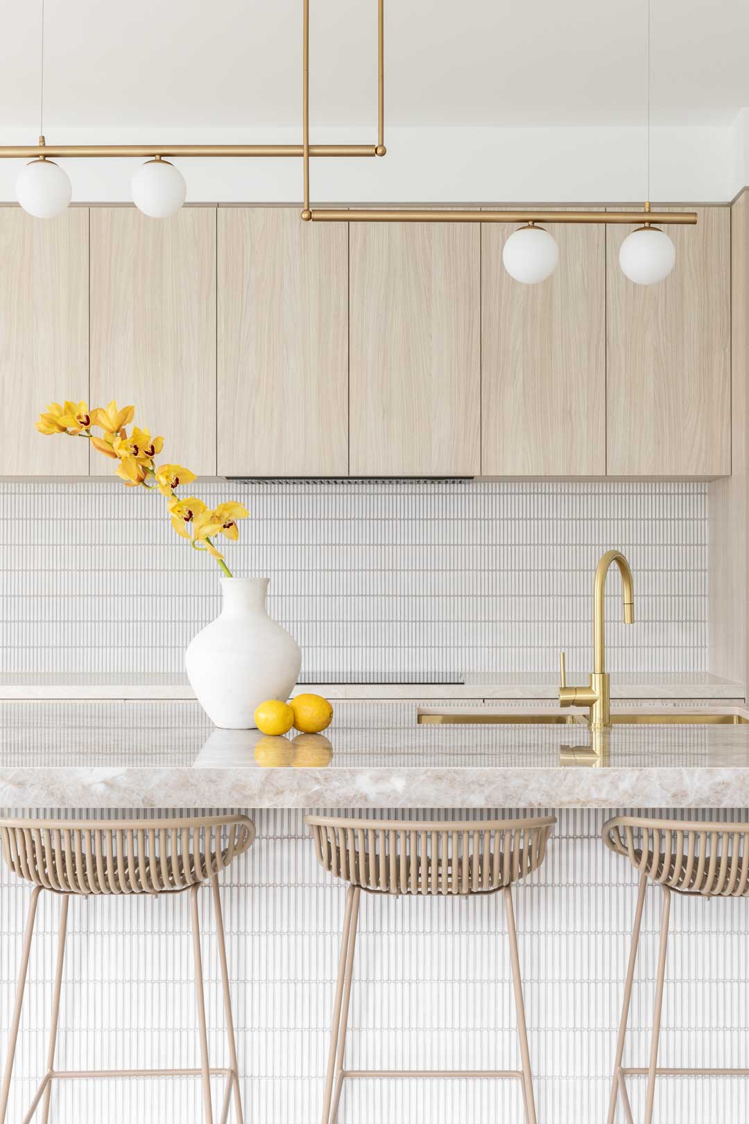 This-luxury-house-tour-of-a-heritage-queenslander-style-house-has-a-warm-kitchen-with-brushed-brass-tapware-soft-timber-cabinetry-and-a-stunning-natural-stone-bench-top