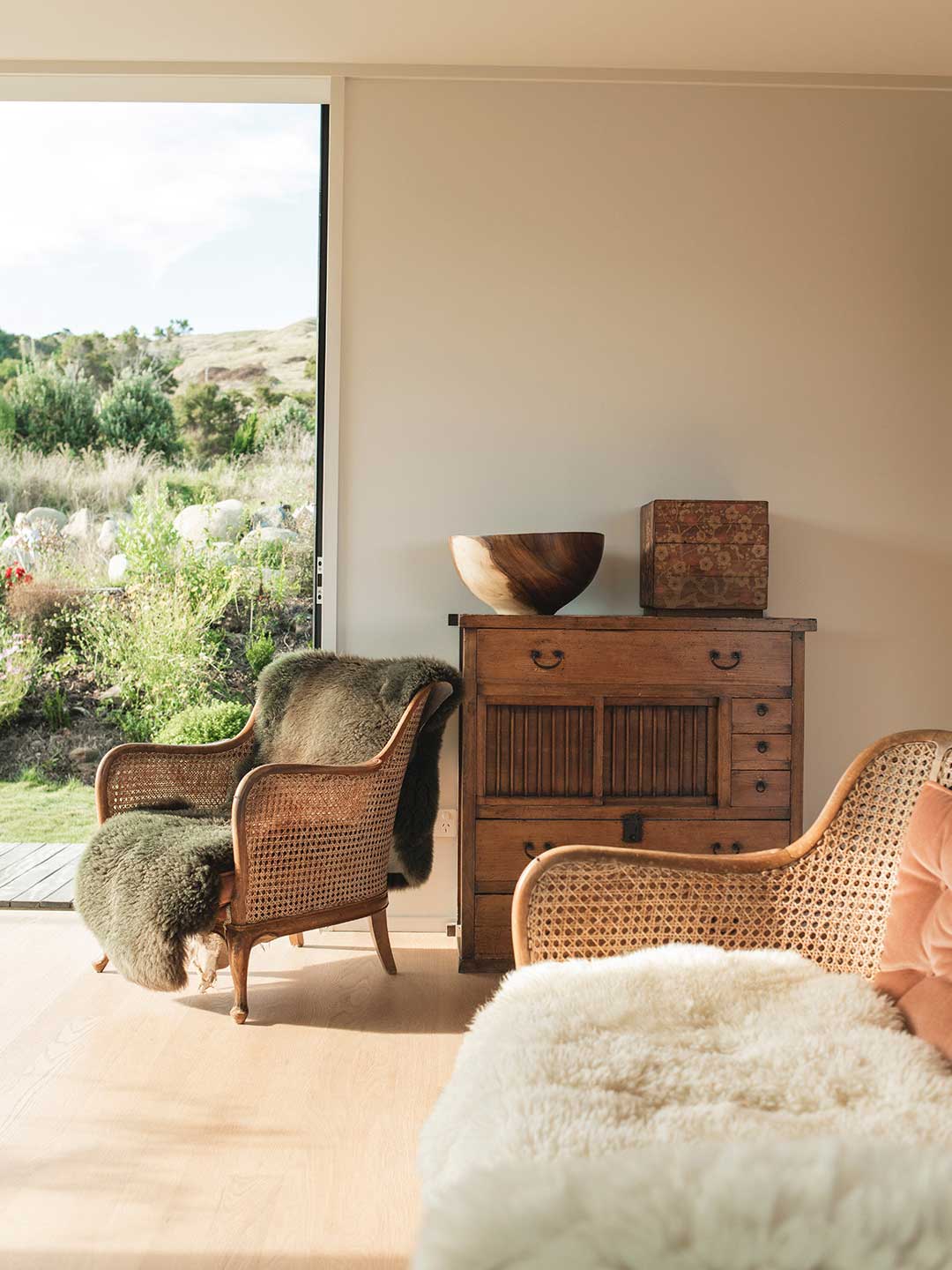 Worn-timber-and-rattan-eclectic-furniture-softened-with-layered-blankets-in-wools-and-furs-for-a-hygge-decor-styled-living-room